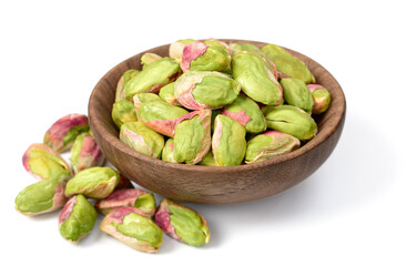 peeled pistachios in the wooden plate, isolated on the white background