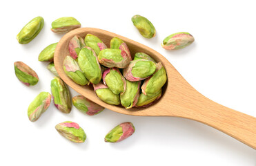 peeled pistachios in the wooden spoon, isolated on the white background, top view