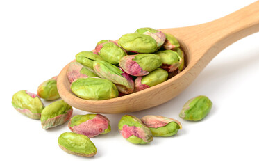 peeled pistachios in the wooden spoon, isolated on the white background