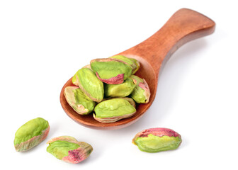peeled pistachios in the wooden spoon, isolated on the white background