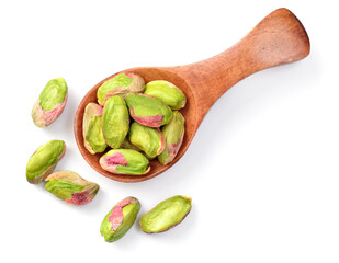 peeled pistachios in the wooden spoon, isolated on the white background, top view