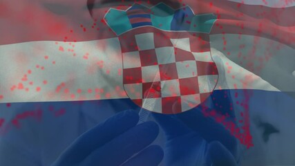 Animation of flag of croatia waving over doctor wearing face mask and holding vaccine - Powered by Adobe