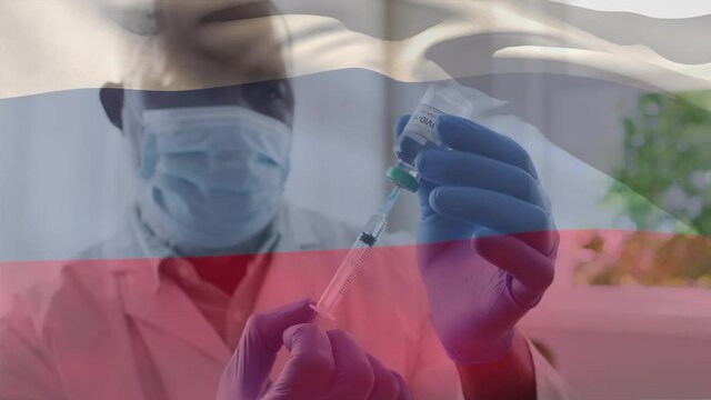 Animation of flag of russia waving over doctor wearing face mask and holding vaccine