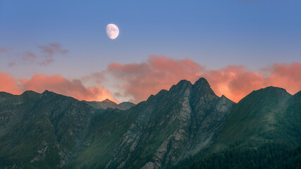 The moon raises over austrian alps at sunset in Serfaus Fiss Ladis region