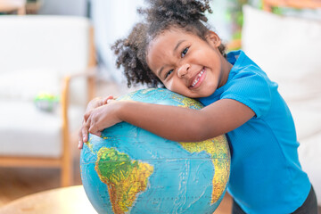 Young girl looking at a globe in library - 458659127
