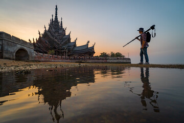 Professional photographer with camera and tripod at summer, sanctuary of truth on the seashore in pattaya, thailand. - 458659146