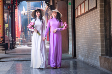Young Vietnam woman wearing Ao Dai culture traditional at old temple at Ho Chi Minh in...