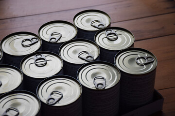 Twelve cans of food with aluminium tear tabs tops