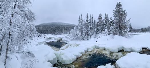 Panorama of winter morning overlooking frozen river and snow-covered trees 