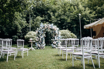 Wedding ceremony in the garden for the bride and groom. Elegant decoration of a wedding ceremony outdoors. Outdoor wedding ceremony.  guest chairs