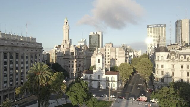 Aerial Drone flying back Cabildo building revealing Buenos Aires cityscape, Argentina. May Square, Famous Revolution's landmark, morning sun.