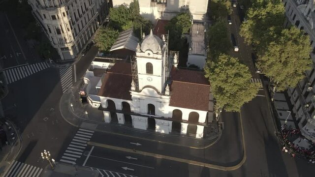 Aerial Drone flying back Cabildo building revealing Buenos Aires cityscape, Argentina. May Square, Famous Revolution's landmark, morning sun.