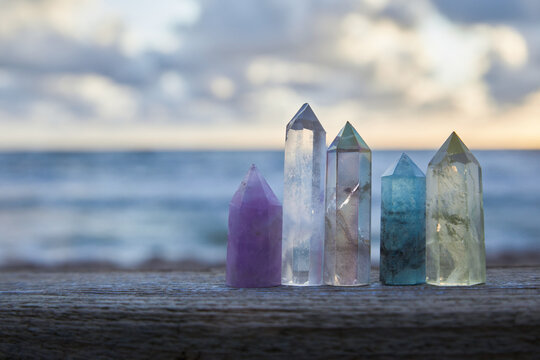 Healing Reiki Crystasls on wood with sea at sunset background. Healing stones at the seaside.