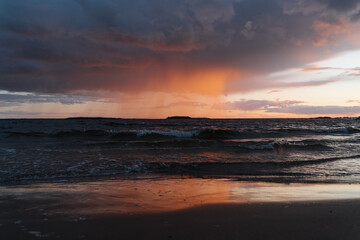 Fototapeta na wymiar Epic Sunset trough a little rain in Finnish Beach