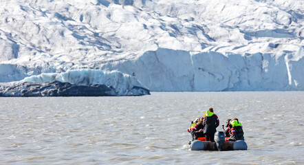 Fjallsarlon, Iceland on July 30, 2021: People in little inflatable rubber boat close to Vatnajokull glacier in Fjallsarlon glacier lagoon in Iceland