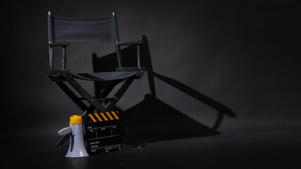 Black director chair and Clapper board or movie Clapperboard with megaphone on black background.use in video production or film cinema industry