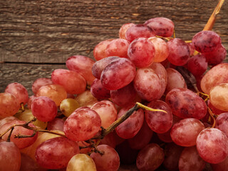 Letters of fresh ripe red grapes on a wooden textured surface. Ancient style, beautiful background with a branch of blue grapes. Red grapes.