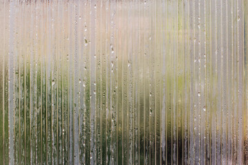 Drawing of water droplets on a transparent polycarbonate sheet. Wavy plastic glass. Rain and UV protection. Background.