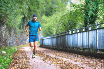 Fototapeta premium Man marathon runner during preparation on bike path