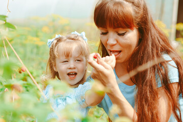 mom hugs her daughter in nature