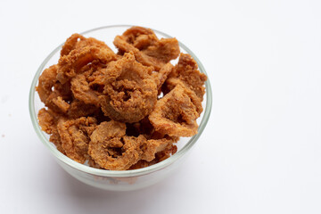 Fried crispy pork belly recipe in glass bowl on white background.