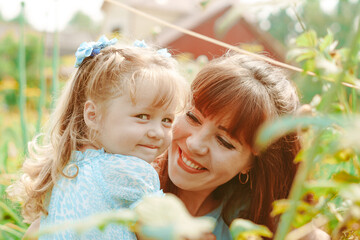 mom hugs her daughter in nature