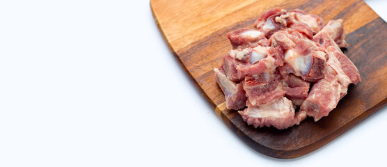 Raw pork ribs on wooden cutting board on white background.