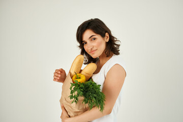 cheerful brunette in a white t-shirt and a bag with apple groceries on her head