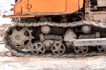 Bulldozer machine is leveling construction site. Earthmover with caterpillar is moving earth. Close-up. Construction heavy machinery.