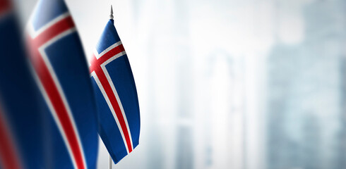 Small flags of Iceland on a blurry background of the city