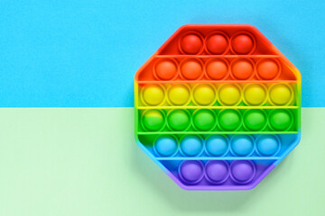 Anti-stress sensory toy popit on green-blue background with copy space