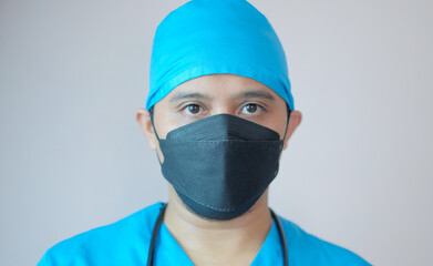 closeup portrait of male doctor wearing face mask and cap