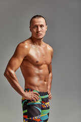Portrait of a swimmer in a cap and mask, half-length portrait, young athlete swimmer wearing a cap and mask for swimming, copies of space, gray background