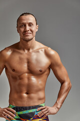 Fototapeta premium Portrait of a swimmer in a cap and mask, half-length portrait, young athlete swimmer wearing a cap and mask for swimming, copies of space, gray background