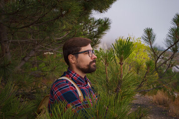 Travel man with backpack hiking in the mountains