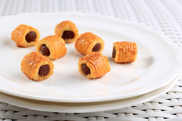 Fresh Baked Pineapple Tart Roll Cookies (Tart Nanas or Kuih Nenas or Nastar Gulung) on White Plate, Isolated