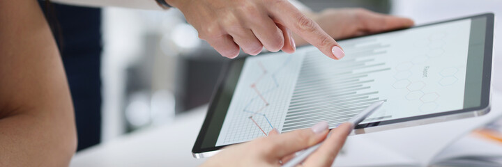 Employees study commercial indicators of business in form of graph on tablet