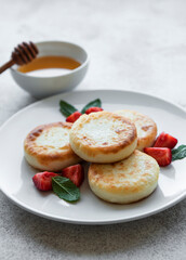 Cottage cheese pancakes, ricotta fritters on ceramic plate with  fresh strawberry.