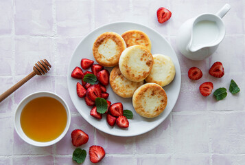 Cottage cheese pancakes, ricotta fritters on ceramic plate with  fresh strawberry.
