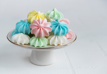 Small colorful meringues on the ceramic  stand