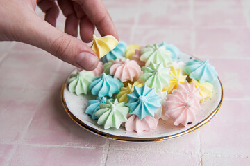 Small colorful meringues in the ceramic  plate