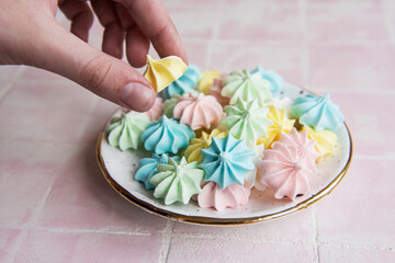 Fototapeta na wymiar Small colorful meringues in the ceramic plate