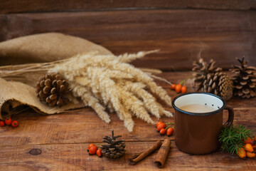 Winter, Christmas background in rustic style. A metal vintage mug with hot milk tea stands on a tablecloth