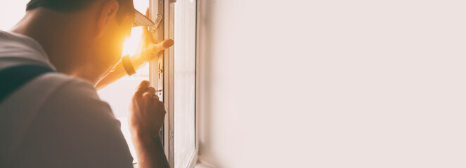 The worker installing and checking window in the house