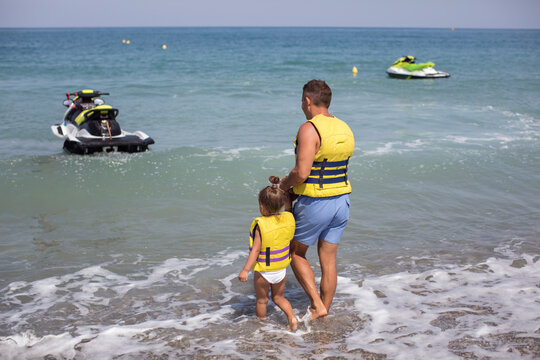 Family father with daughter going on a hydrocycle