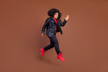 Fototapeta na wymiar Full body profile portrait of carefree energetic overjoyed girl isolated on brown color background