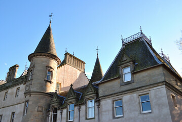 Fototapeta premium French Style Scottish Baronial Building-Angled View from Below against Blue Sky