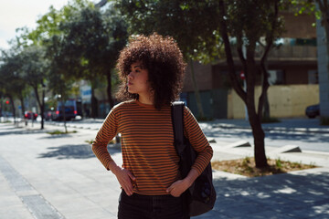 Cute young woman looking around while walking