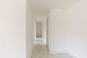 Interior of a long white corridor in empty apartment