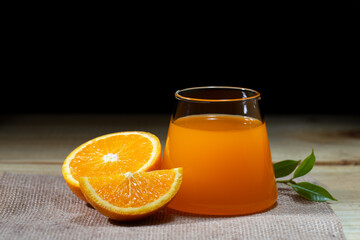 Fresh orange juice in glass or bottle with sliced fruits, Objects on black background. light and shadow tone